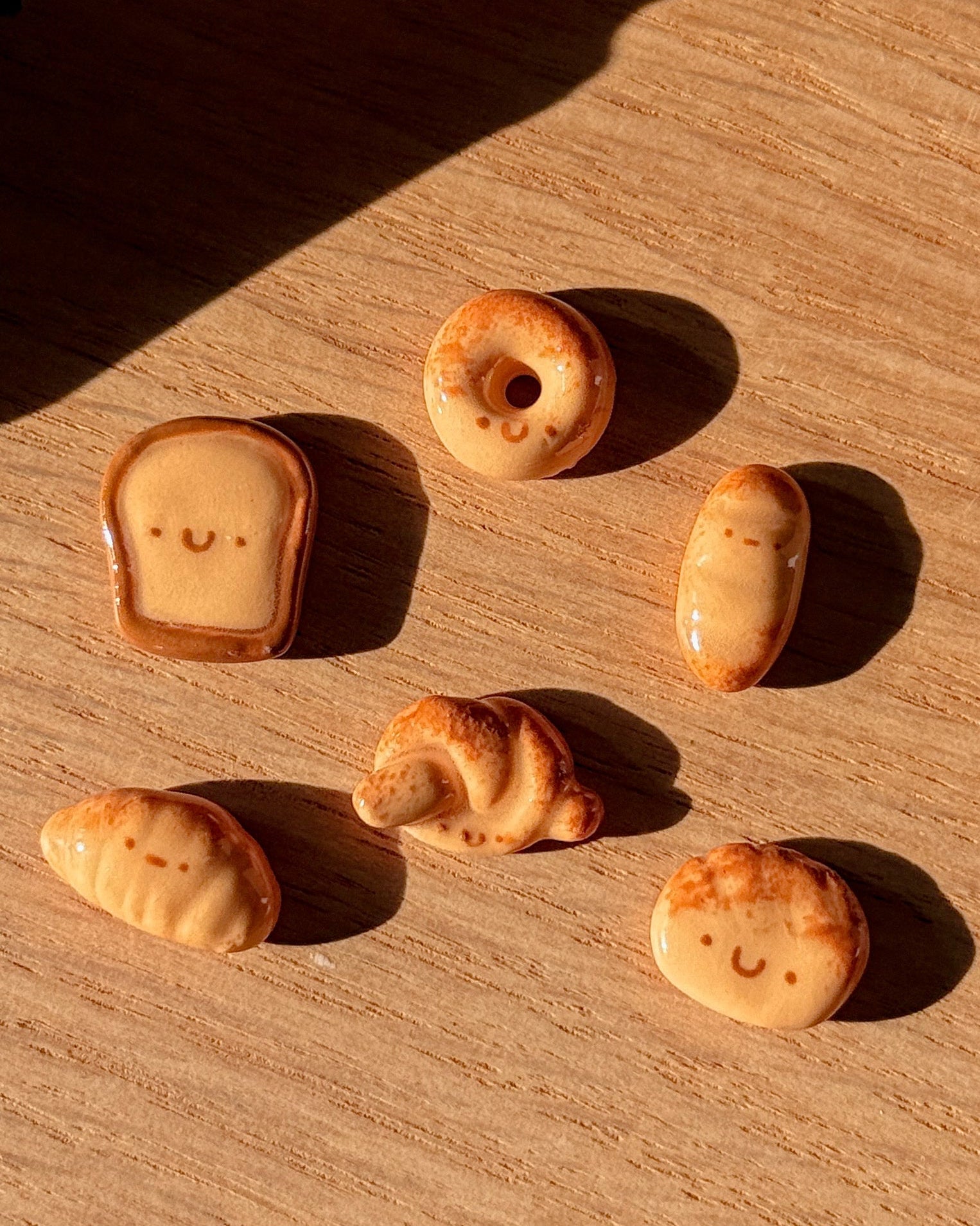 Small food-shaped cookies on a wooden surface with a warm light.